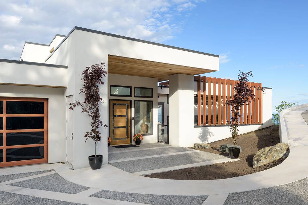 white home with sloping driveway