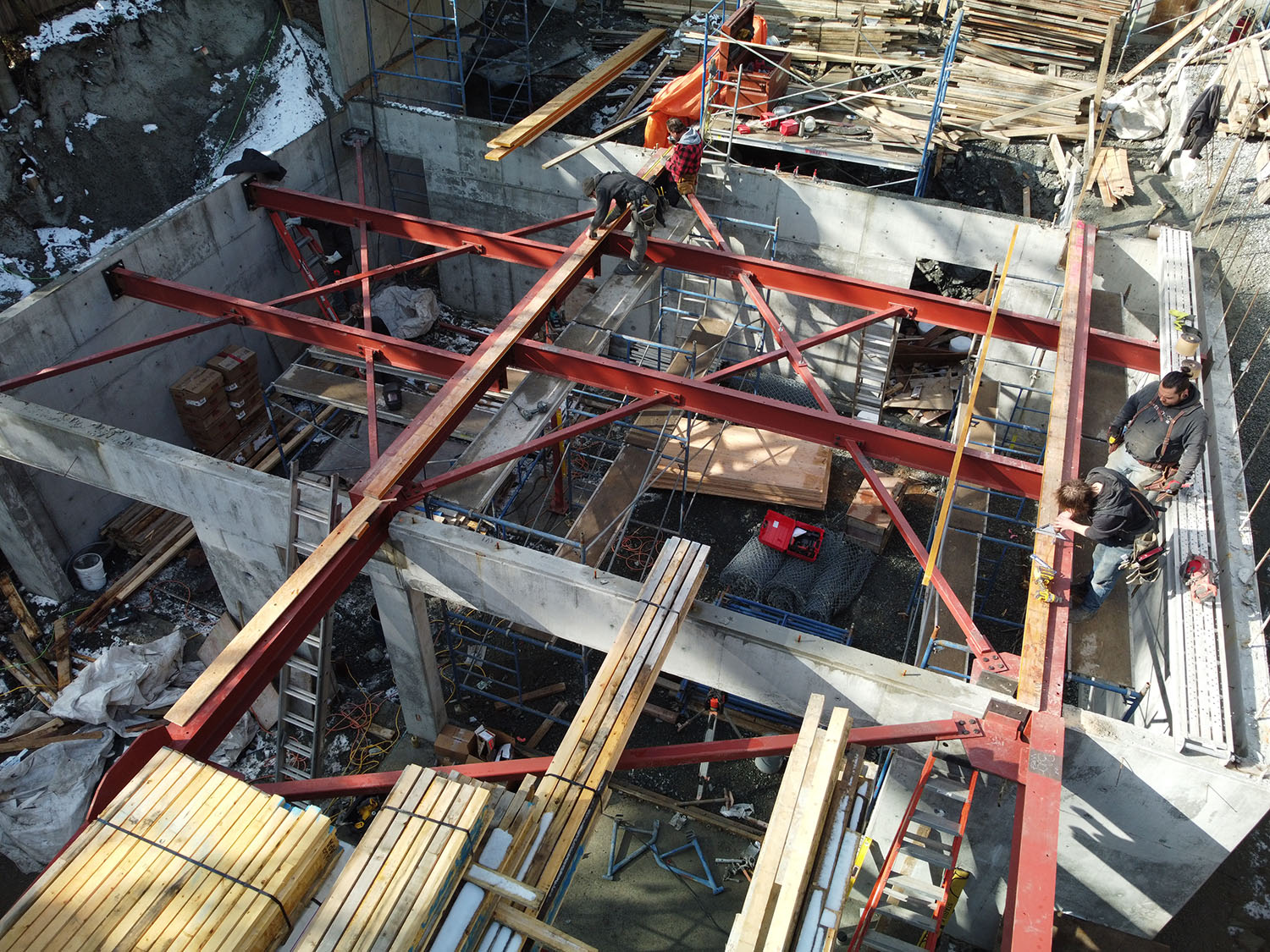 Horizon Pacific Contracting construction team installing steel I-beams during large residential building framing.